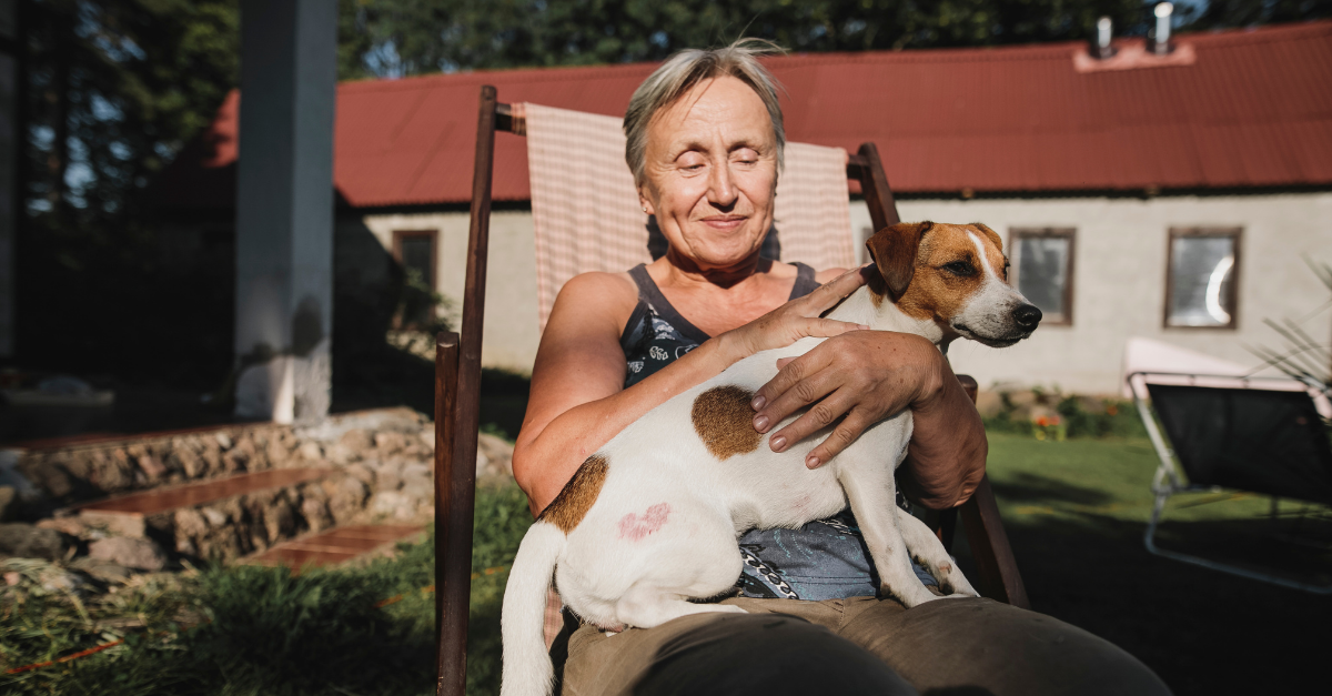 older woman holds a dog in her lap